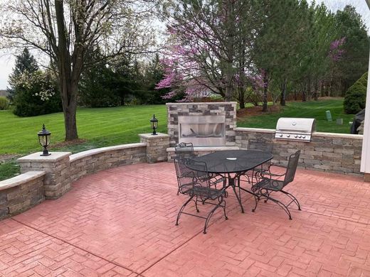 Stamped Concrete A patio with a table and chairs and a fireplace.