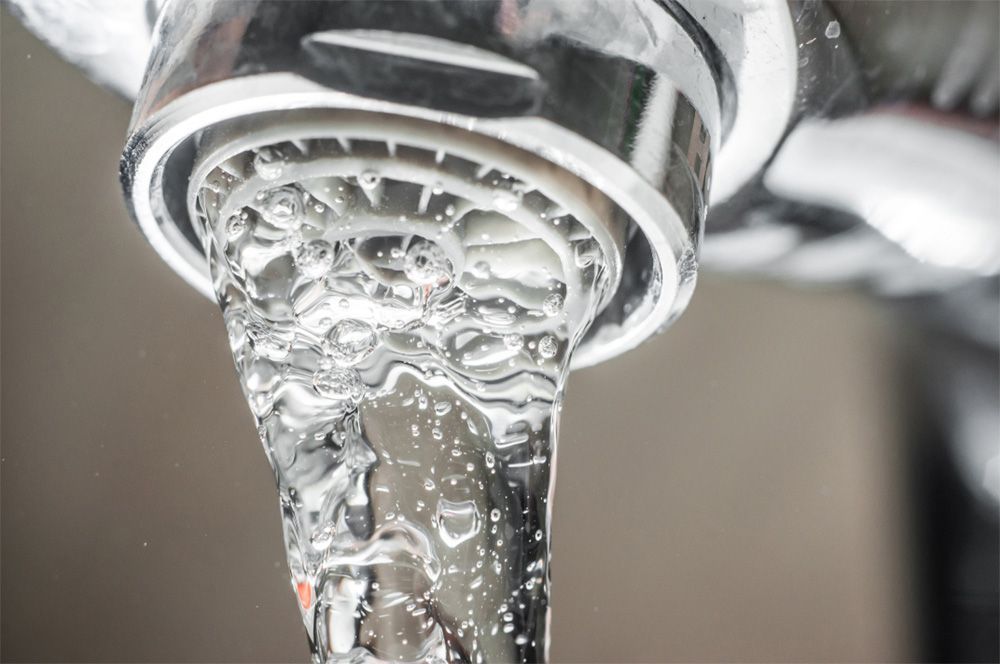 A close up of a faucet with water running out of it.