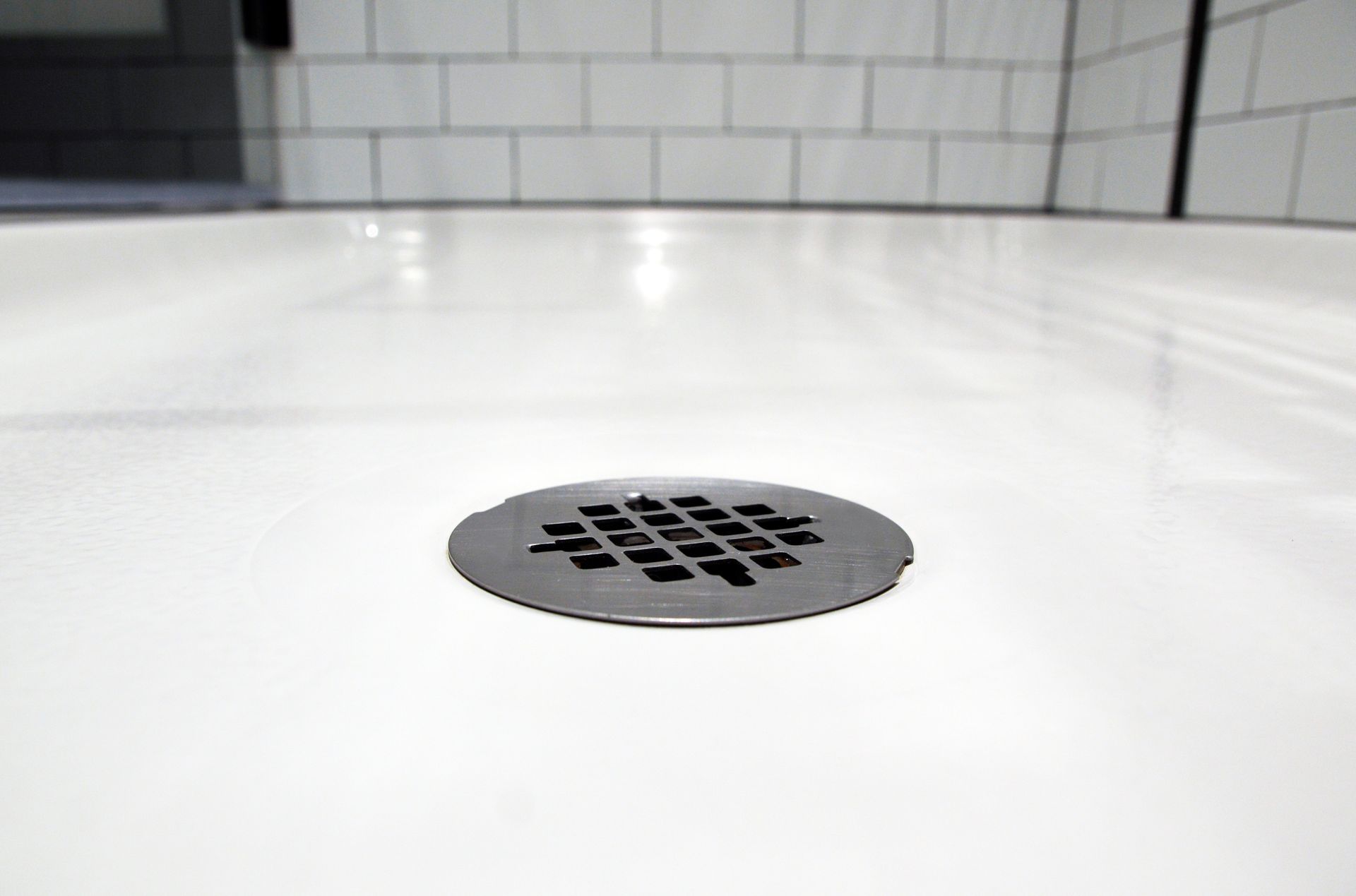 A close up of a shower drain in a bathroom.