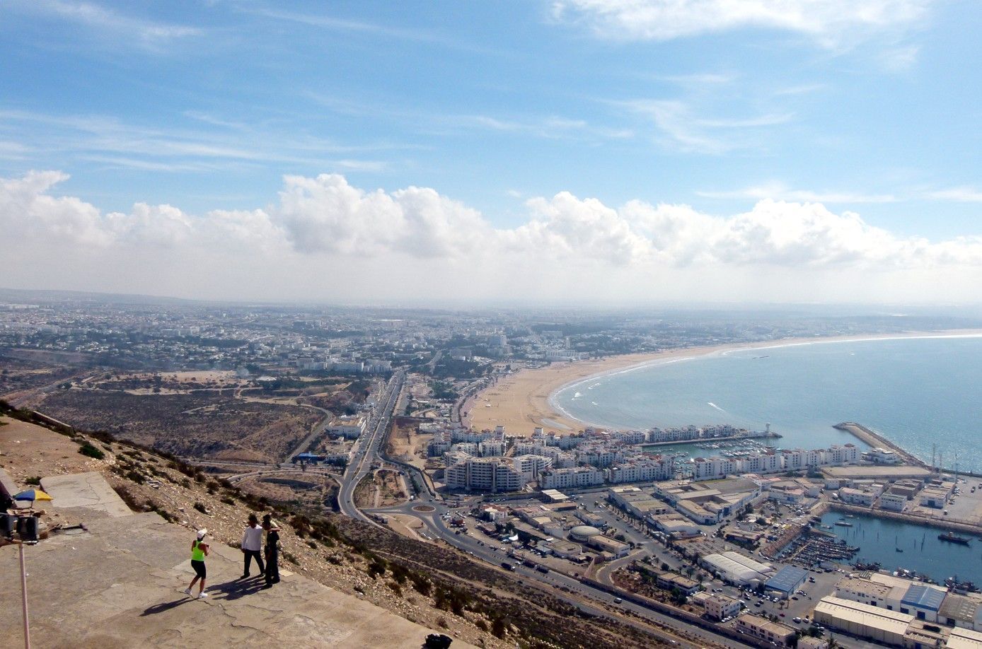 Uitzicht op Agadir, Marokko, vanaf een heuveltop. Gebouwen staan ​​langs de kust en grenzen aan de blauwe oceaan onder een heldere hemel.