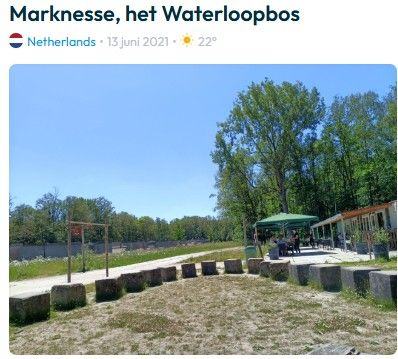 Een park in Marknesse, Nederland, op een zonnige dag. Groene bomen, een kleine zithoek en een wandelpad.