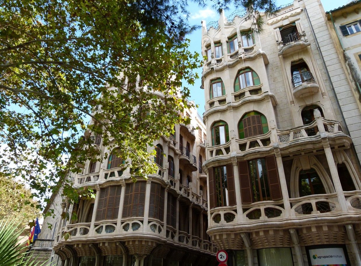 Sierlijke, lichtgekleurde appartementengebouwen met gebogen balkons, Palma de Mallorca.