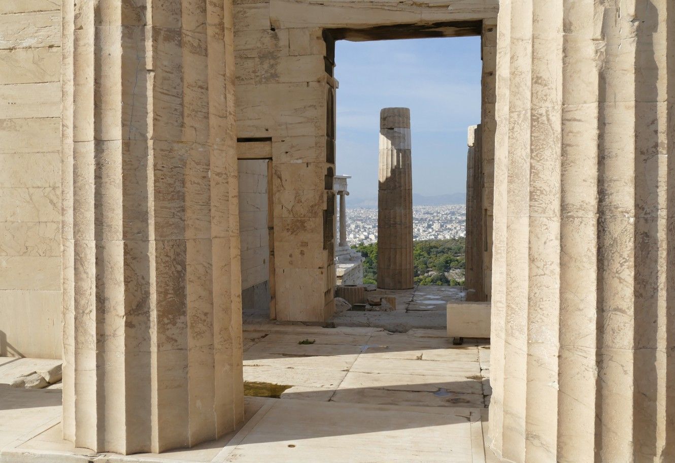 Stenen zuilen omlijsten een uitzicht op Athene, Griekenland; overblijfselen van oude architectuur.