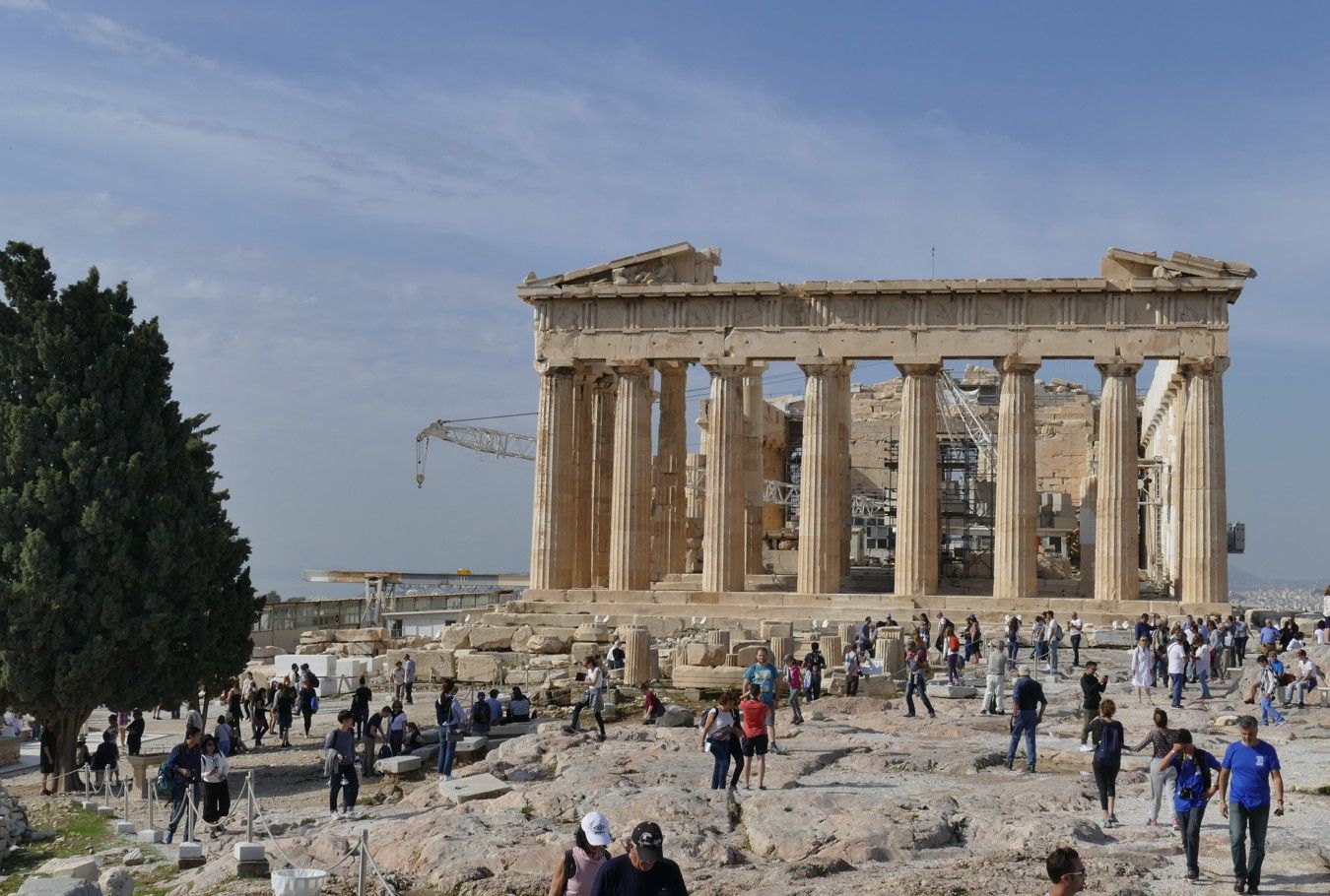 Het Parthenon in Athene, met talloze toeristen die er op een zonnige dag rondlopen.