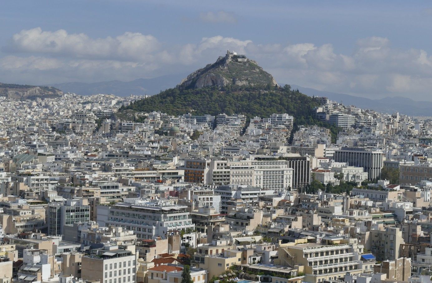 Uitzicht op Athene, Griekenland, met het stadsbeeld op de voorgrond en de berg Lycabettus op de achtergrond.