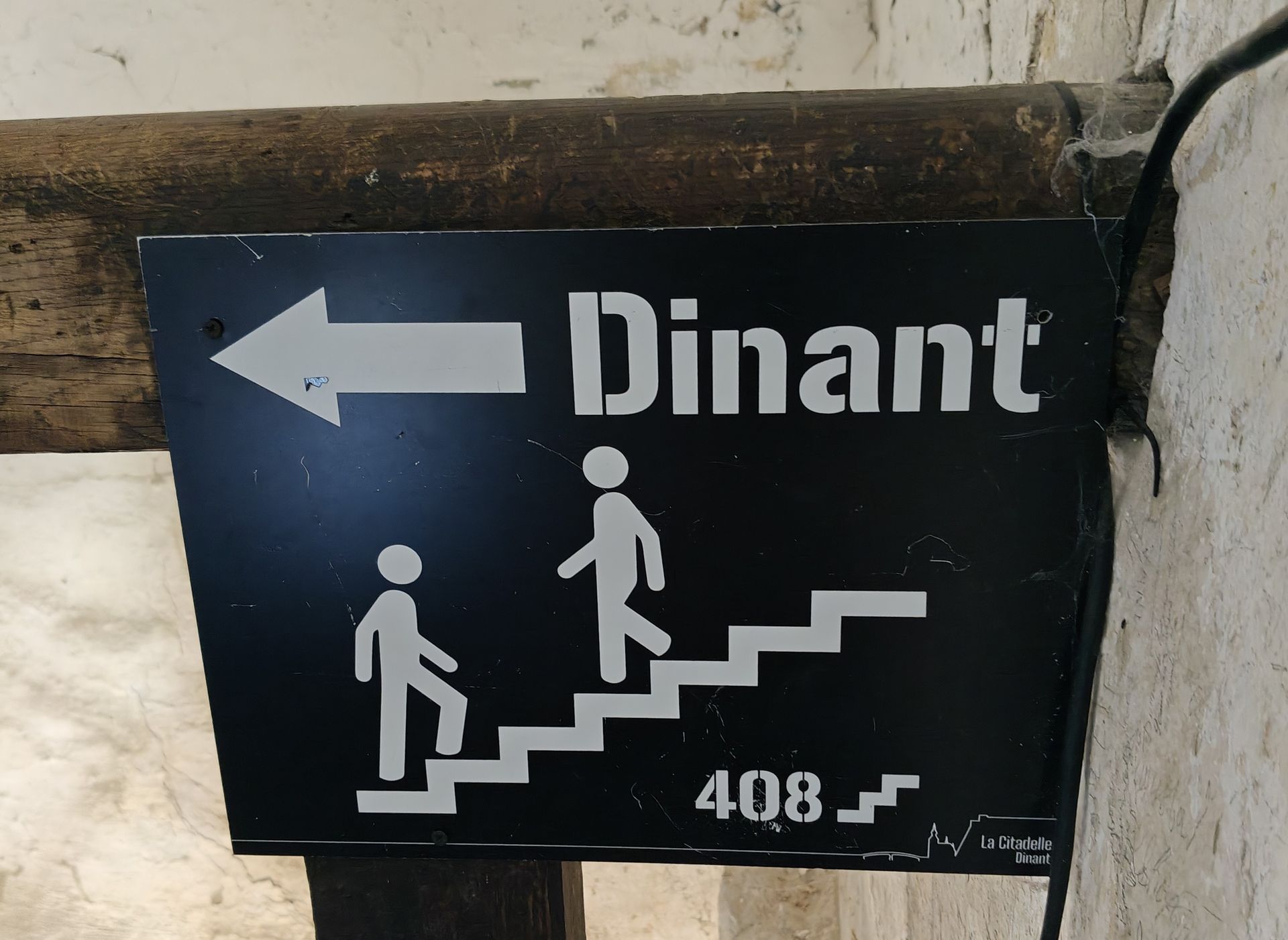 Zwart bord met wit trapicoon en pijl, met de tekst 