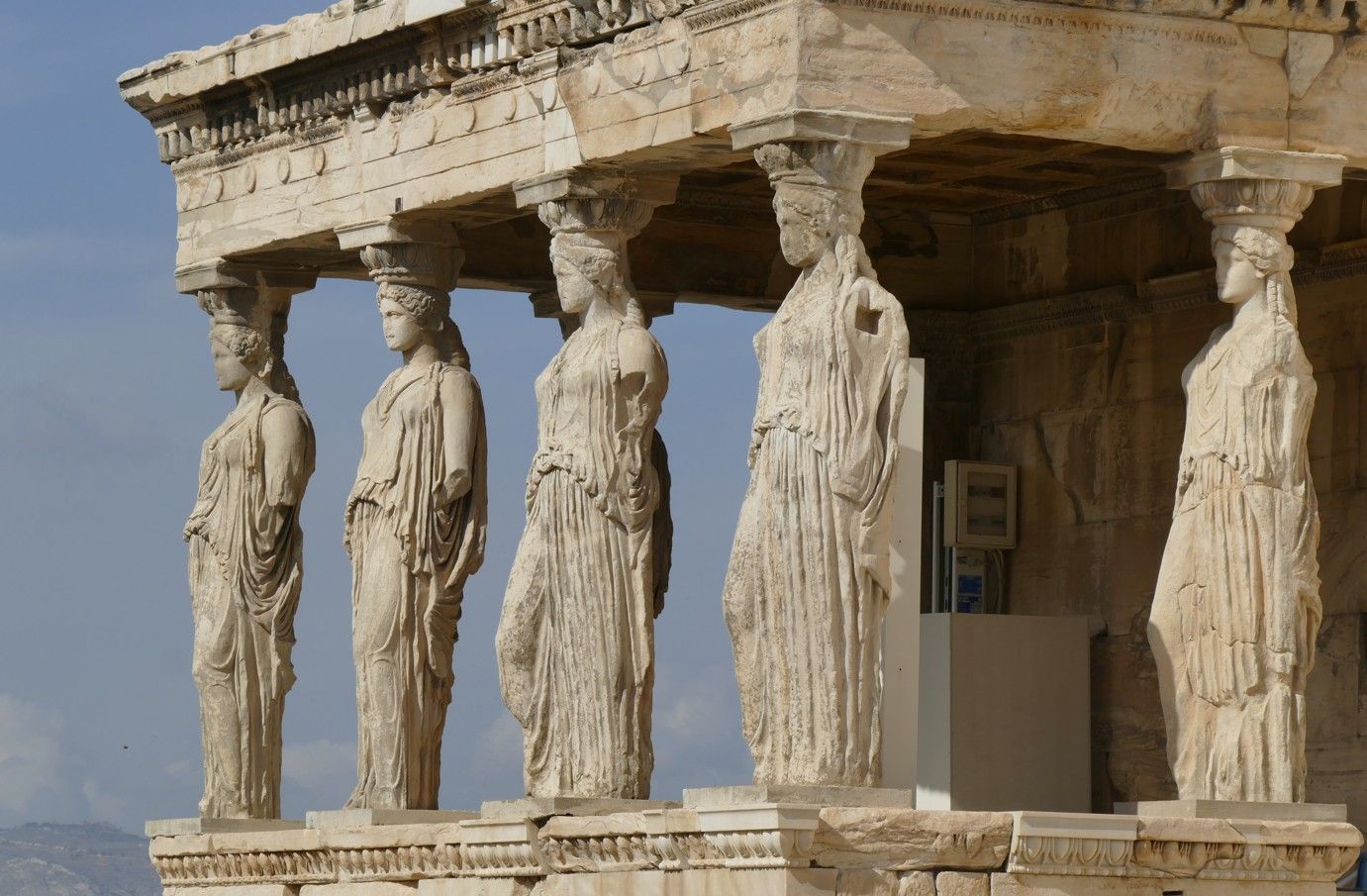 Kariatiden, gebeeldhouwde vrouwelijke figuren, ondersteunen het dak van de Erechtheion-tempel op de Akropolis in Athene.