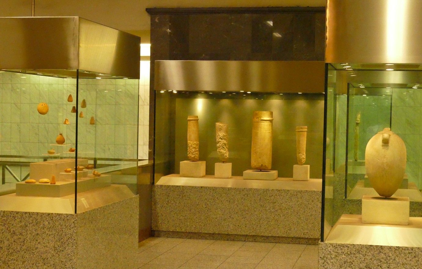 Museumtentoonstelling van oude voorwerpen in glazen vitrines.