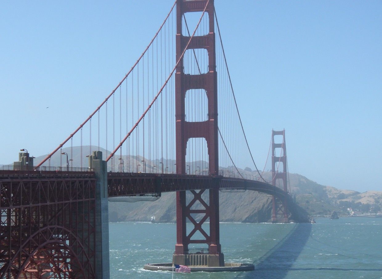 De Golden Gate Bridge overspant het water op een heldere dag, met een blauwe lucht en helder water.