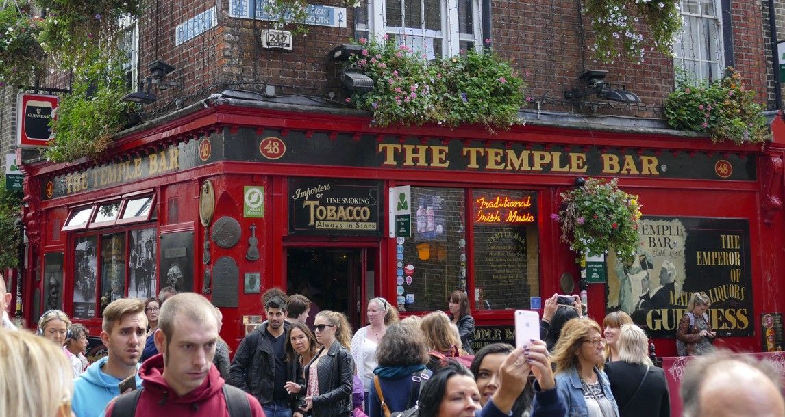 De buitenkant van de pub Red Temple Bar met een menigte mensen.