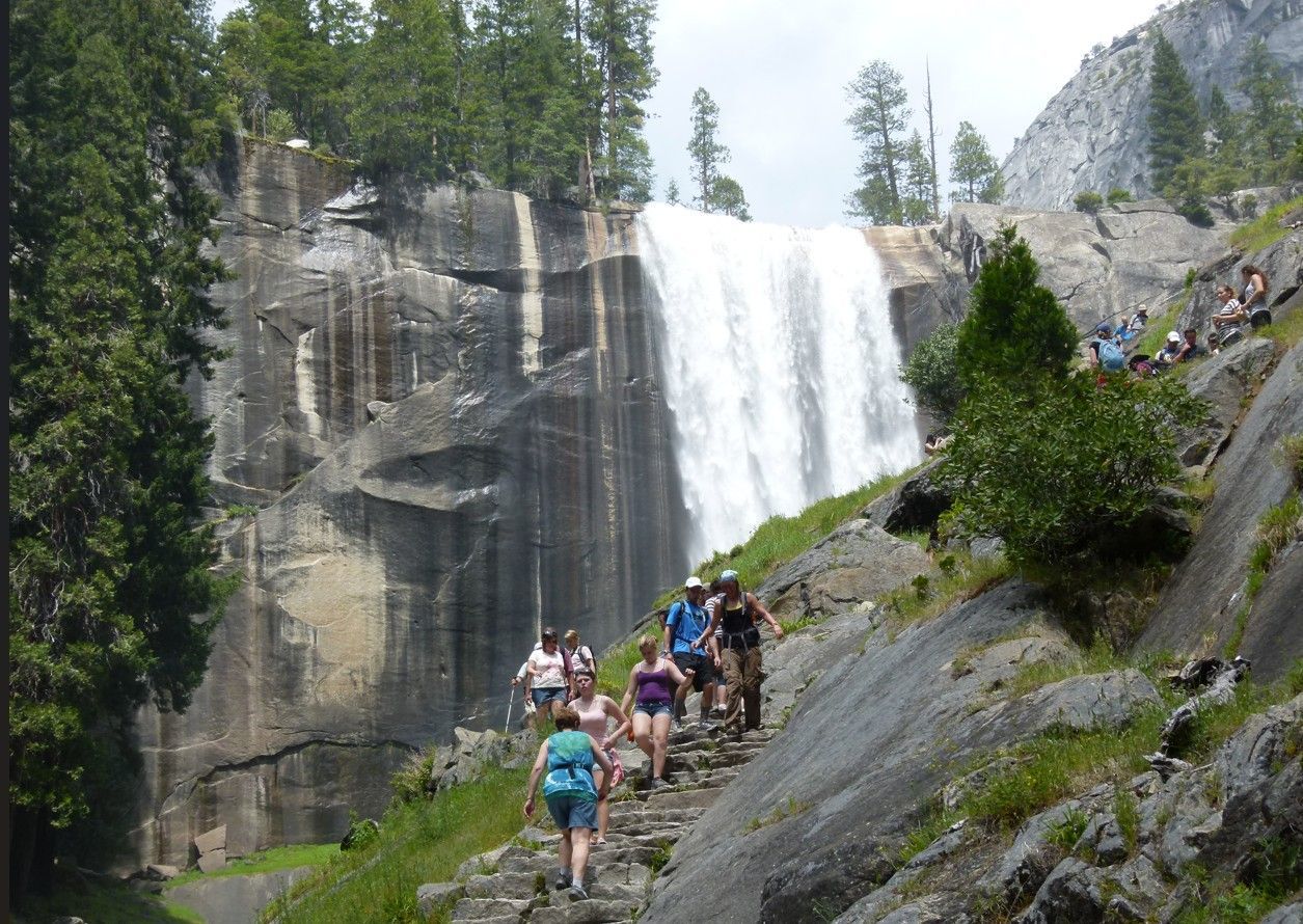 Mensen beklimmen stenen trappen naar een waterval in Yosemite National Park.