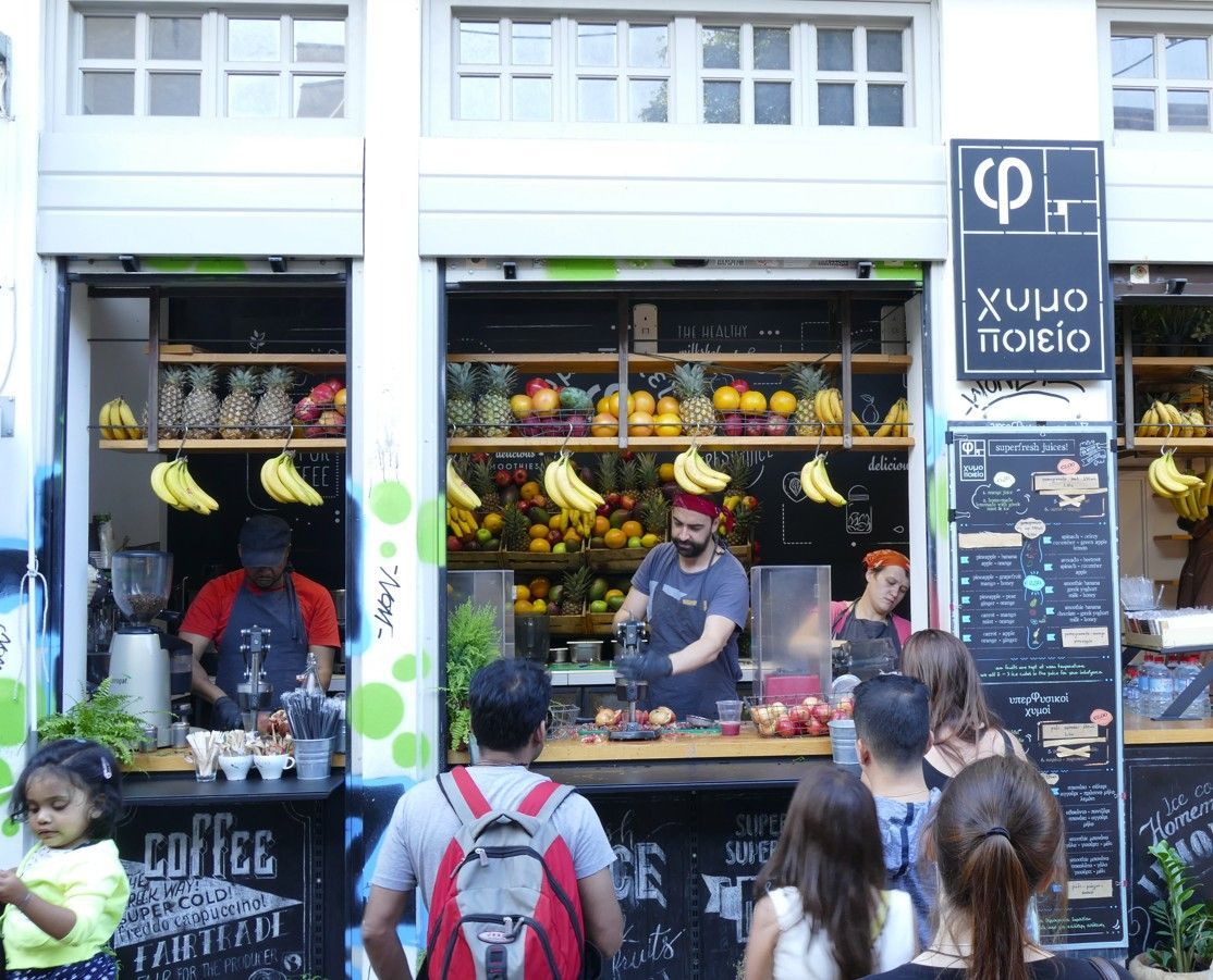 Fruitkraam met medewerkers en klanten; fruit uitgestald; Athene, Griekenland.
