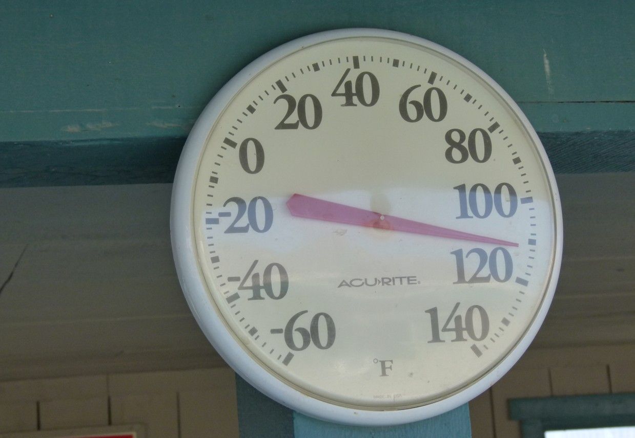 De thermometer geeft ongeveer 110 graden Fahrenheit aan. De wijzerplaat is wit met zwarte cijfers.