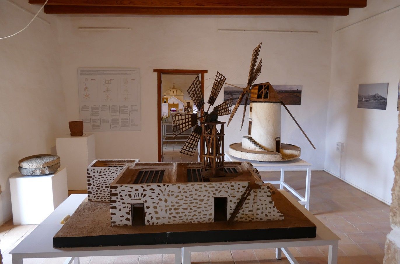 Modelwindmolens tentoongesteld in een museum met witte muren.