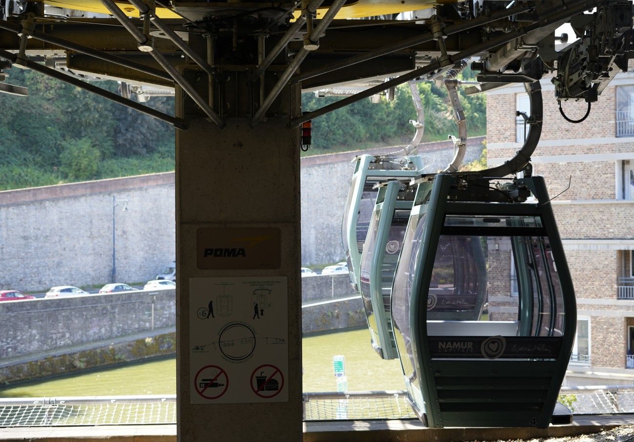 Een kabelbaanwagon in een station, van binnenuit gezien, met een pilaar op de voorgrond.