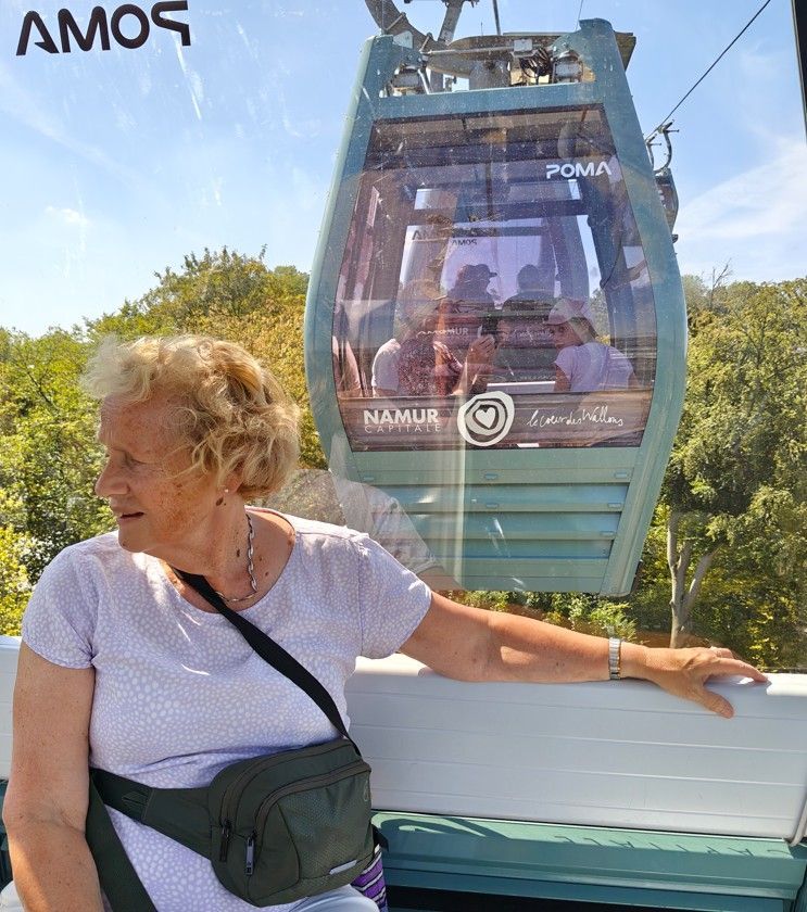 Vrouw in een gondellift met een schilderachtig uitzicht op de bergen op de achtergrond.