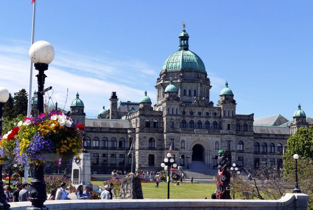 Het parlementsgebouw van Brits-Columbia in Victoria, met een groene koepel en een blauwe lucht.