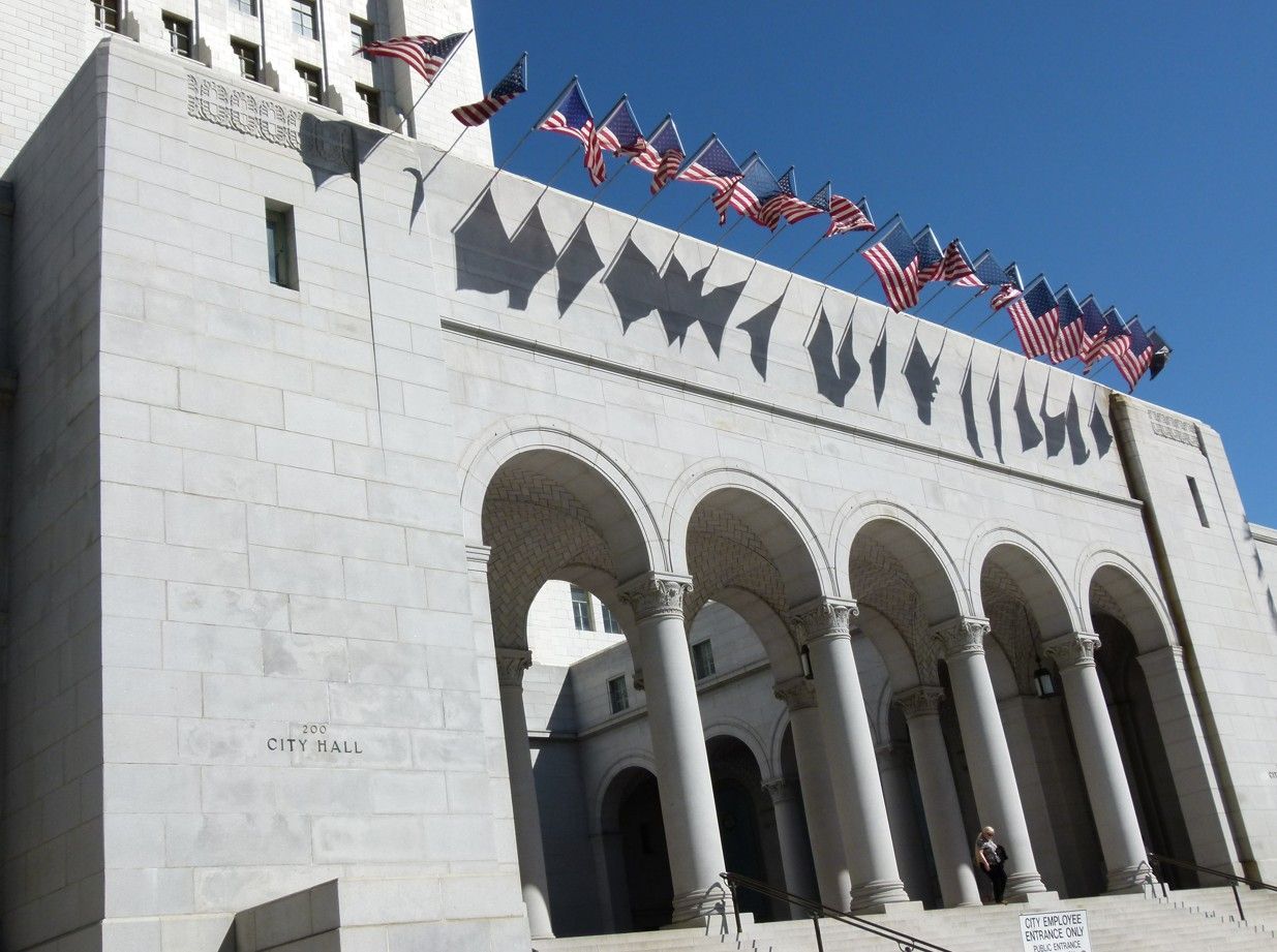 Het stadhuis van Los Angeles met Amerikaanse vlaggen op een zonnige dag.