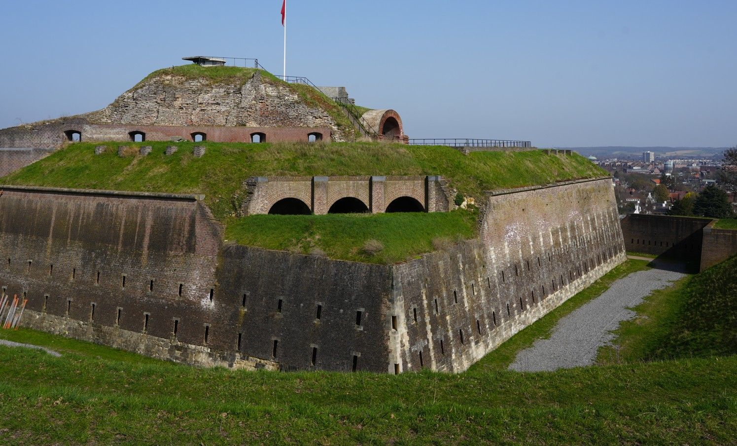 De stenen vesting  heeft met gras begroeide wallen en een trapsgewijs opgebouwd bakstenen bastion.