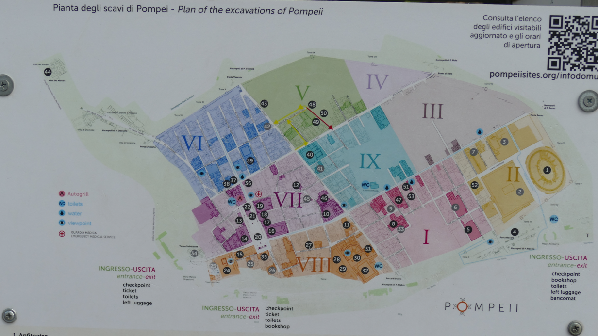 Plattegrond van de ruïnes van Pompeii, verdeeld in genummerde secties, met een kleurgecodeerde legenda.
