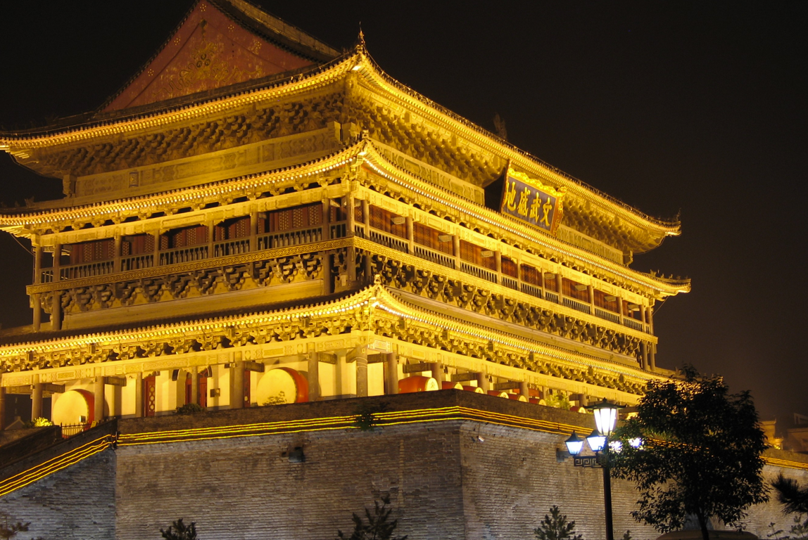 Een verlichte oude Chinese klokkentoren 's nachts.