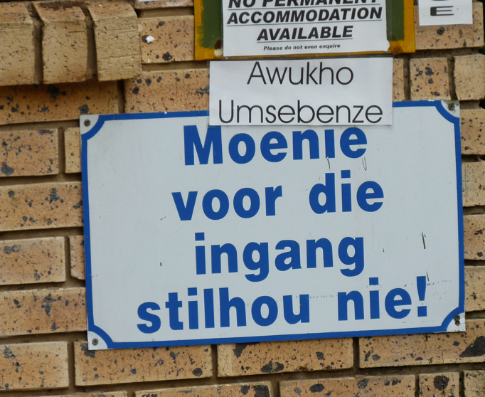 Bordje op bakstenen muur: 