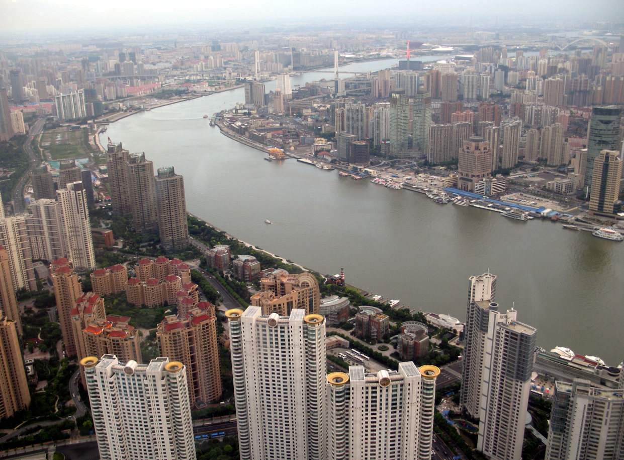 Luchtfoto van Shanghai, China, met gebouwen langs de rivier de Huangpu op een bewolkte dag.