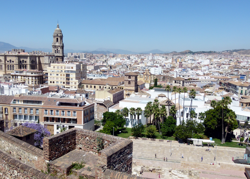Stadsgezicht van Málaga, Spanje, met de kathedraal en in de verte bergen onder een blauwe hemel.