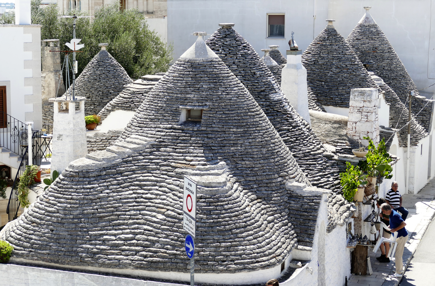 Stenen gebouwen met kegelvormige daken in Alberobello, Italië, met witgekalkte muren.