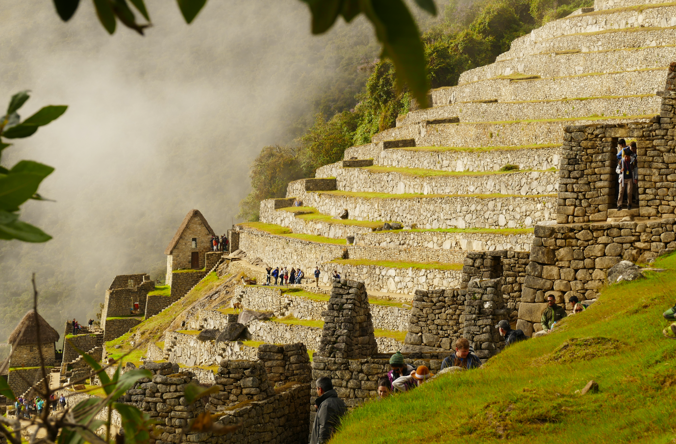 De ruïnes van Machu Picchu op een heuvel, stenen bouwwerken, terrasvormige hellingen en mist.