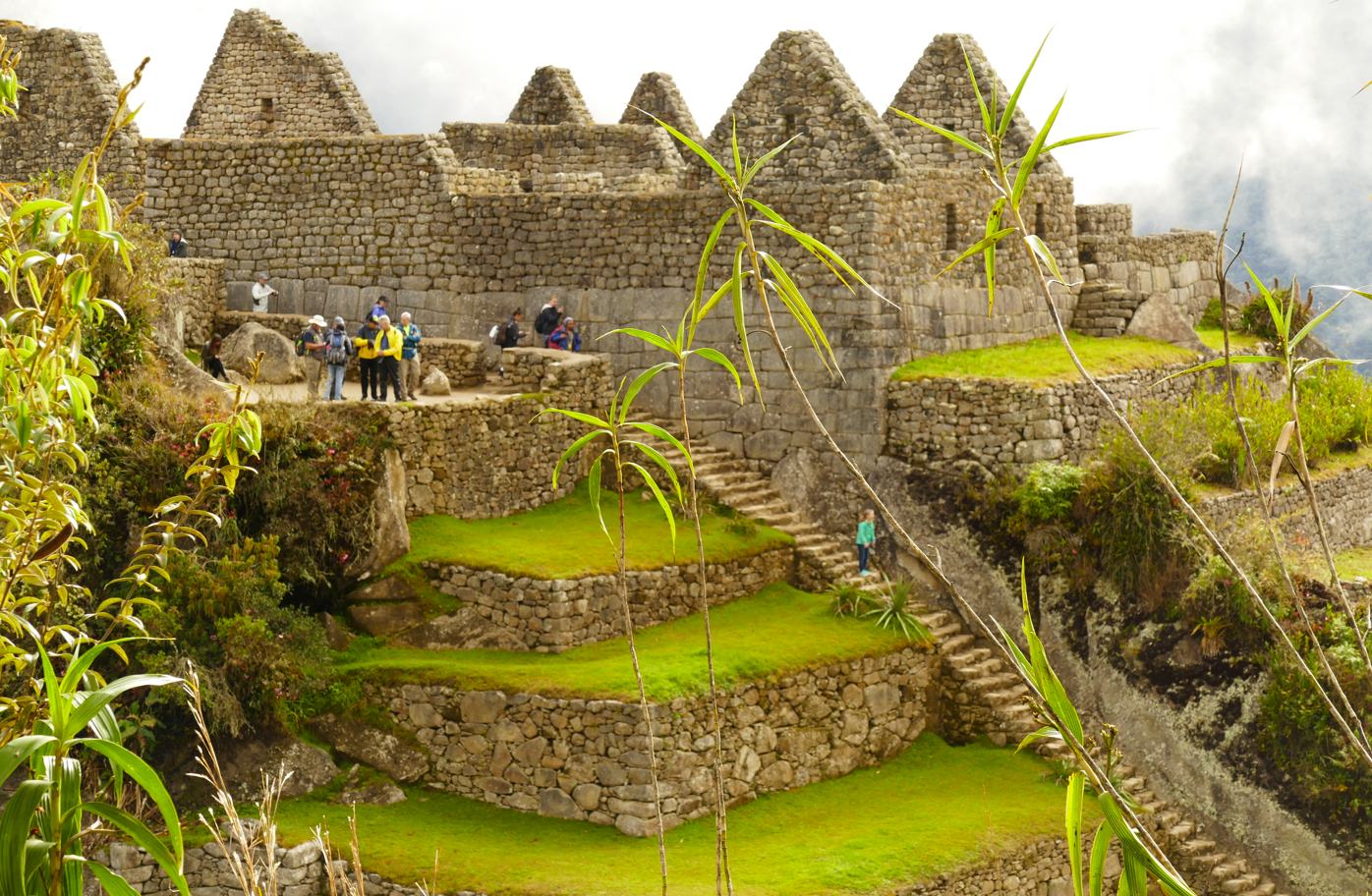 Stenen ruïnes van Machu Picchu met terrasvormige trappen en mensen, Peru.