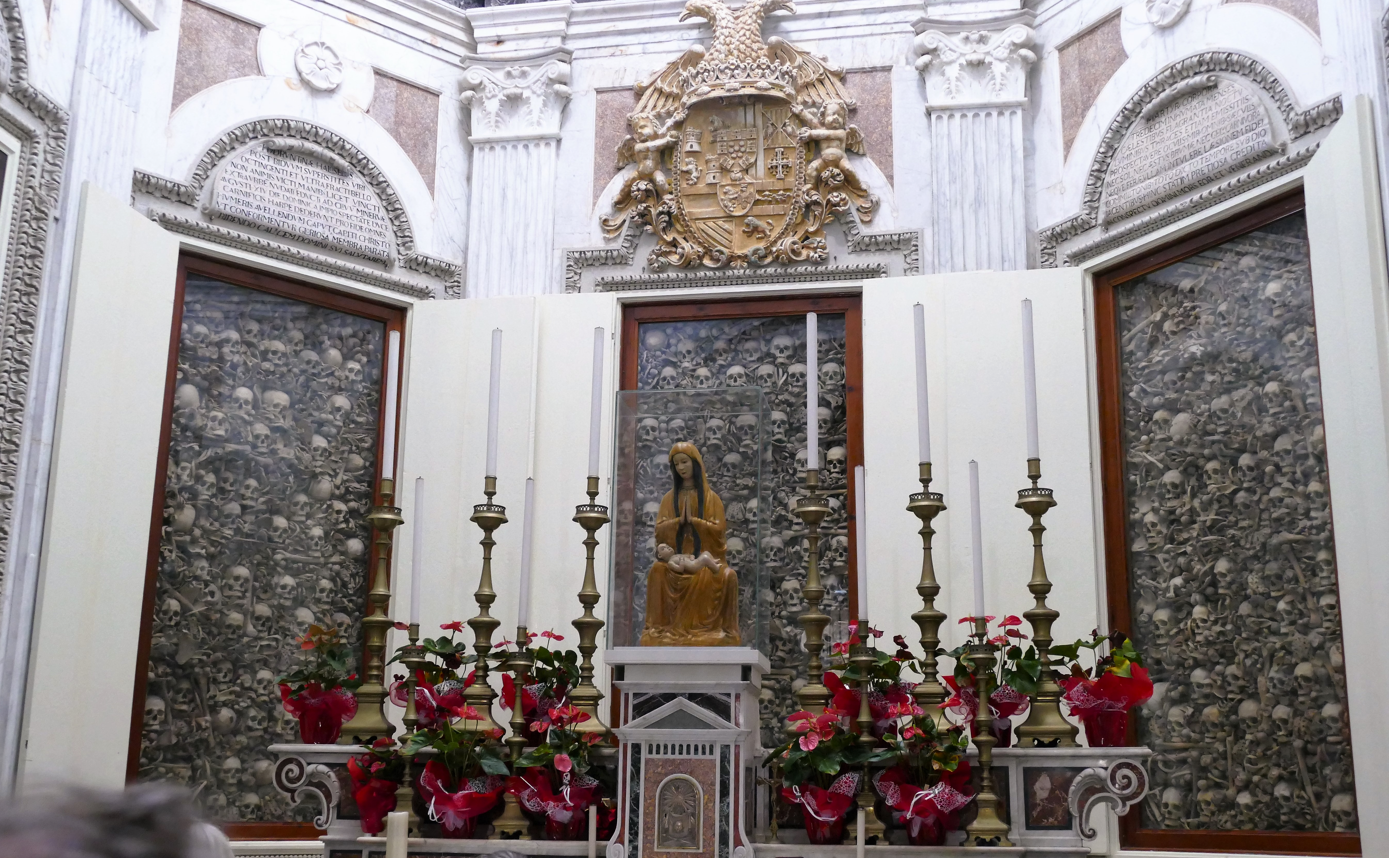 Het interieur van een kerk, versierd met schedels, een standbeeld en kandelaars, vermoedelijk voor religieuze doeleinden.