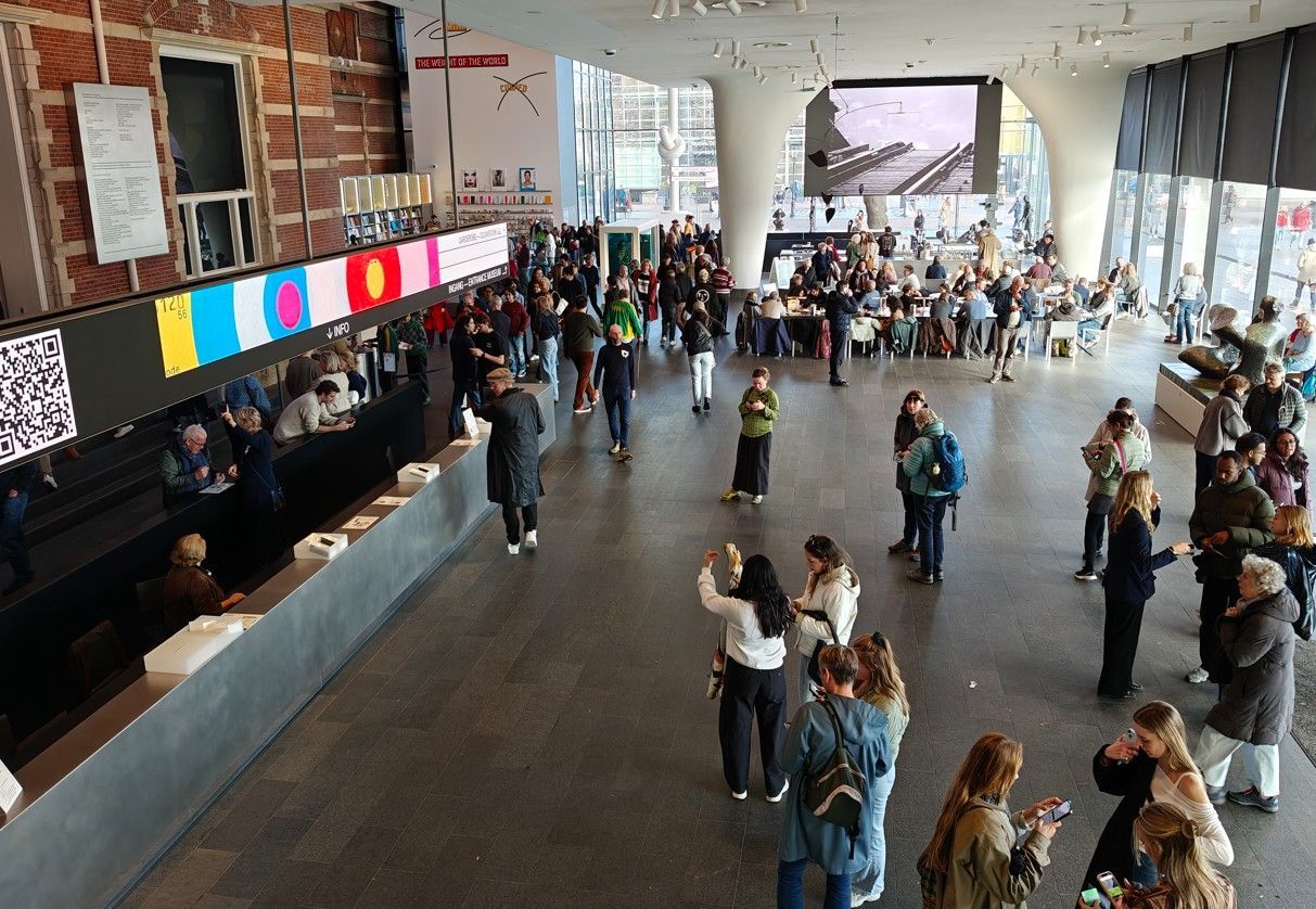 Media museum - Grote, moderne galerie met bezoekers die kunstwerken bekijken en een scherm. 