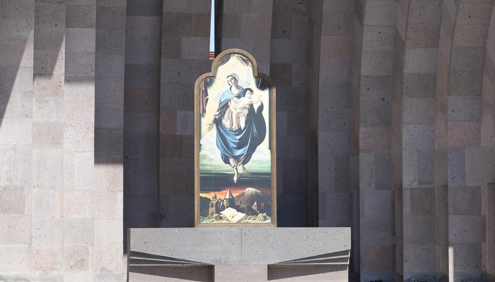 Klein altaar met een ingelijst religieus beeld van de Heilige Maagd Maria in een stenen kerkmuur.