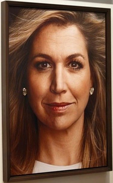 Portret van een vrouw met lang, lichtbruin haar en diamanten oorbellen. Ze heeft een subtiele glimlach.