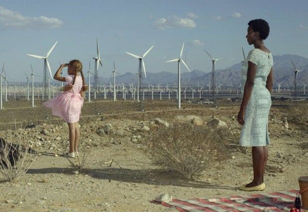 Foto van Erwin Olaf - Twee vrouwen staan ​​in een woestijnlandschap met windmolens op de achtergrond.