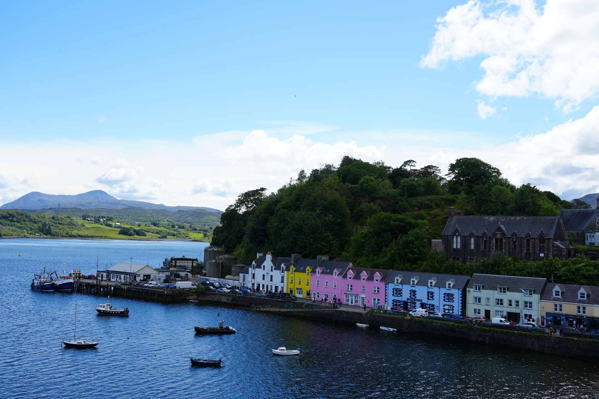 Kleurrijke gebouwen sieren de haven van Tobermory in Schotland. Boten liggen verspreid over het water.