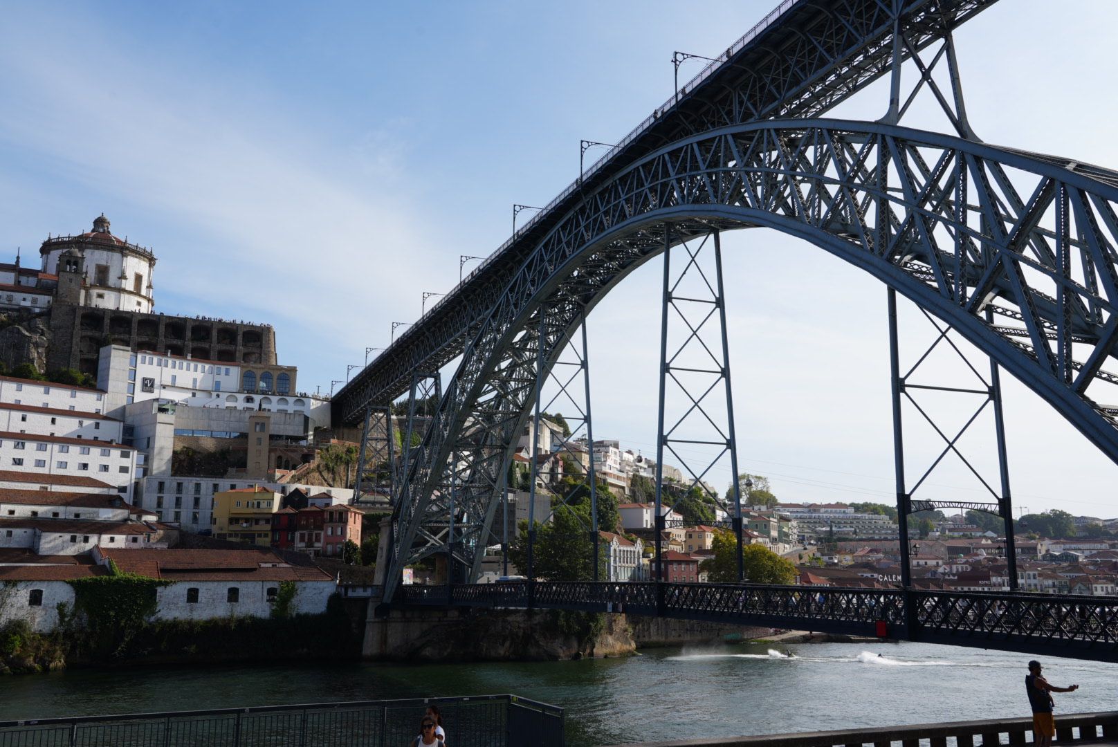 De Dom Luís I-brug boog zich over de rivier de Douro in Porto, Portugal, met stadsgebouwen op de achtergrond.