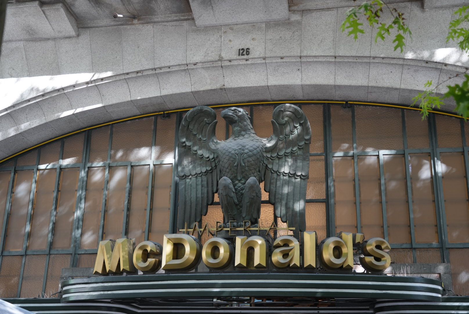 Het uithangbord van een McDonald's-restaurant met gouden letters en een adelaarsbeeld erboven.