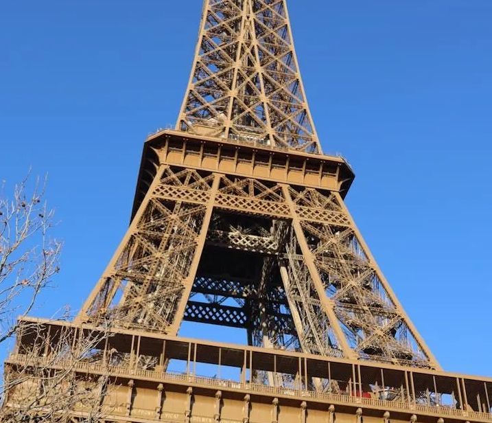 Eiffeltoren, Parijs. Bronzen ijzeren vakwerkconstructie tegen een helderblauwe hemel.