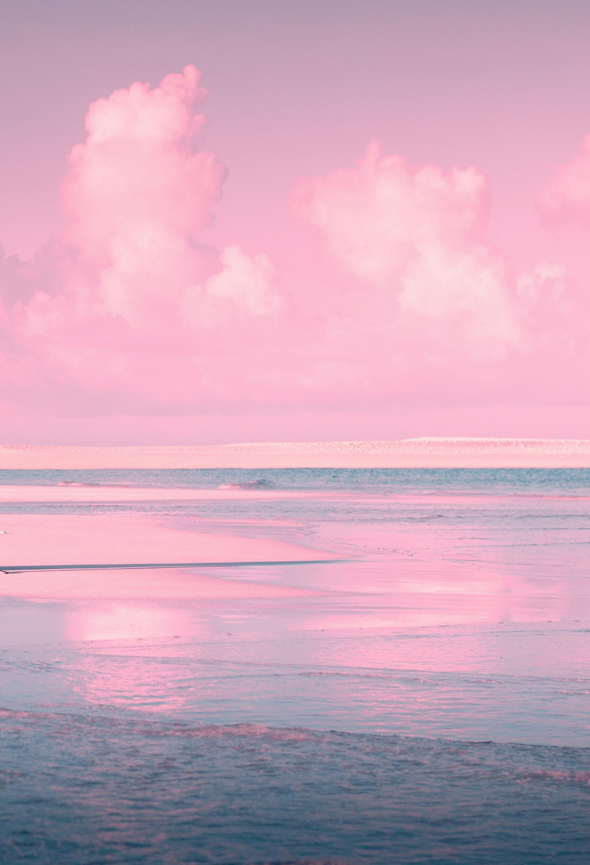 Roze lucht en wolken die weerspiegelen in het kalme oceaanwater.