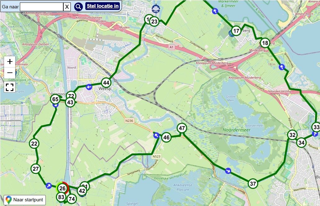 Kaartscreenshot met een groene routelus en blauwe markeringen op een terreinkaart.