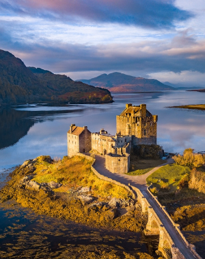 Eilean Donan Castle in Schotland staat op een eiland met een stenen brug. Het kasteel is omgeven door bergen en water