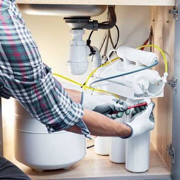 Technician installing or repairing system of water filtration