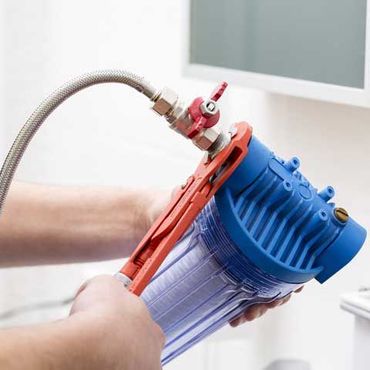 Plumber installing new water filter