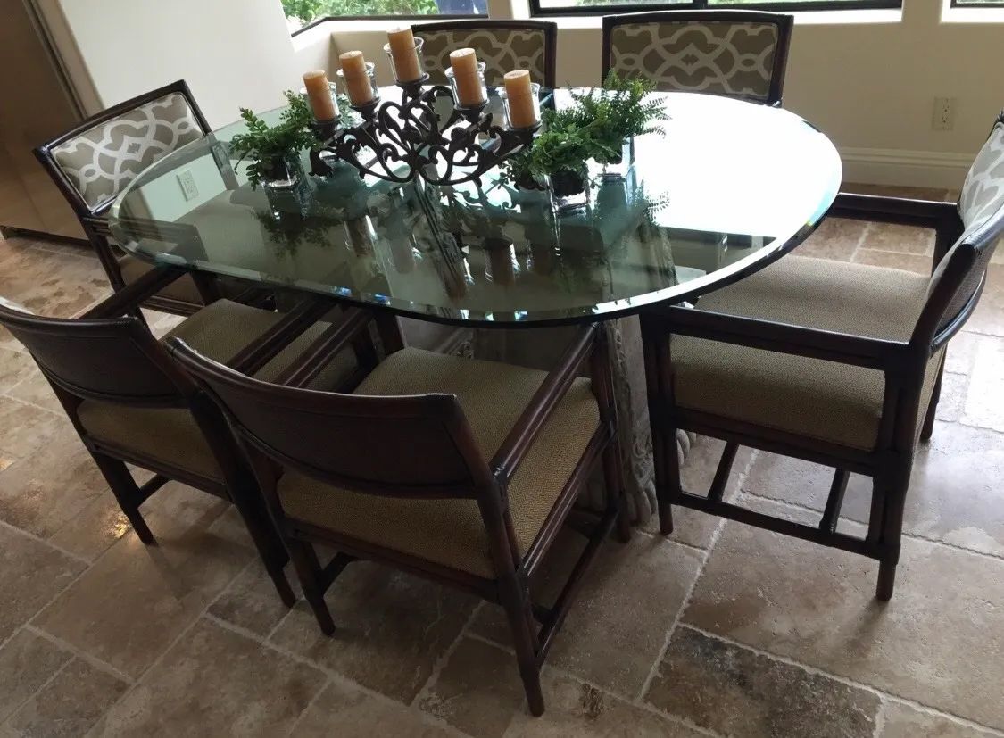 A dining room table and chairs with candles on it