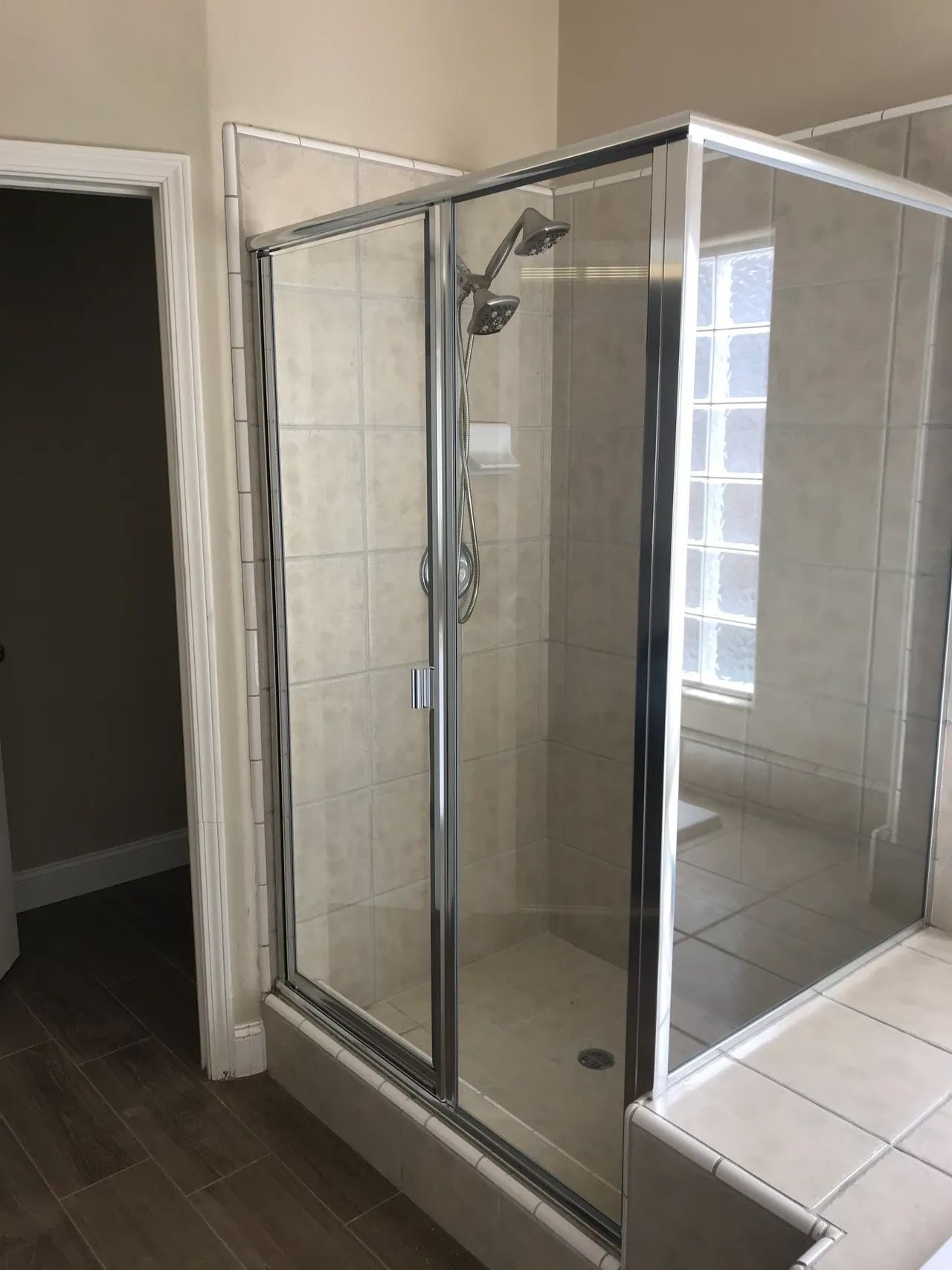 A bathroom with a shower stall and a window