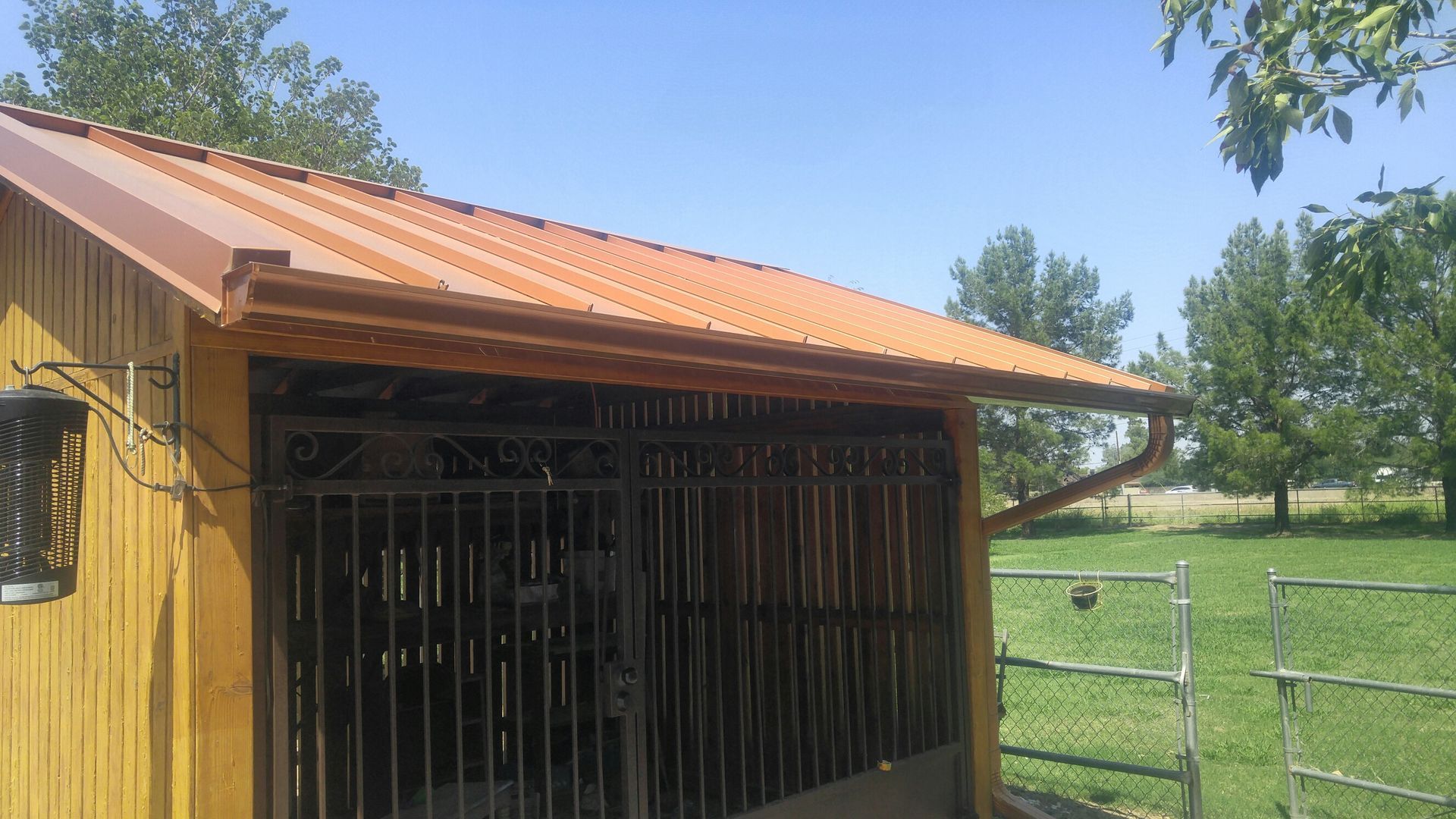 Aluminum downspout installed at the corner of a Chandler, AZ home directing water to a splash block.