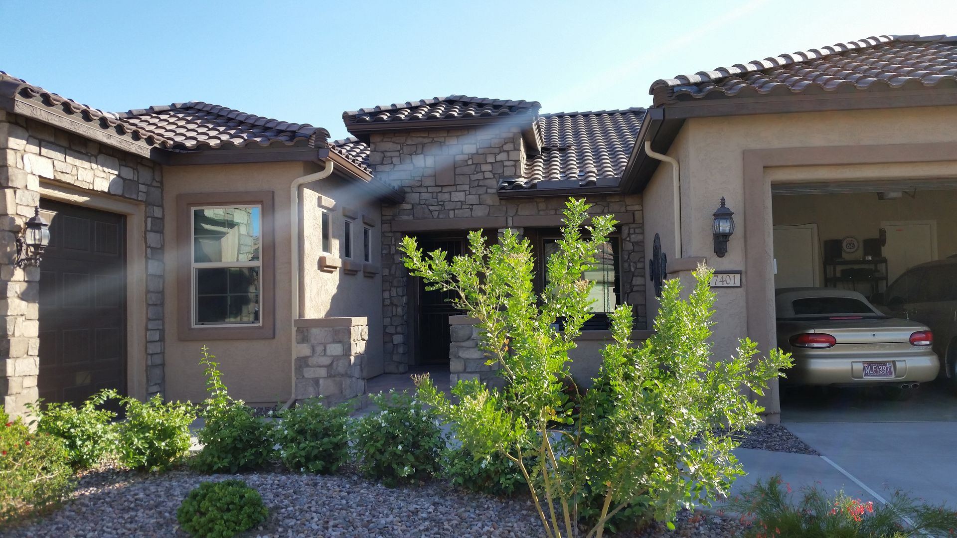 Technician resealing a leaking gutter joint on a Chandler-area home.