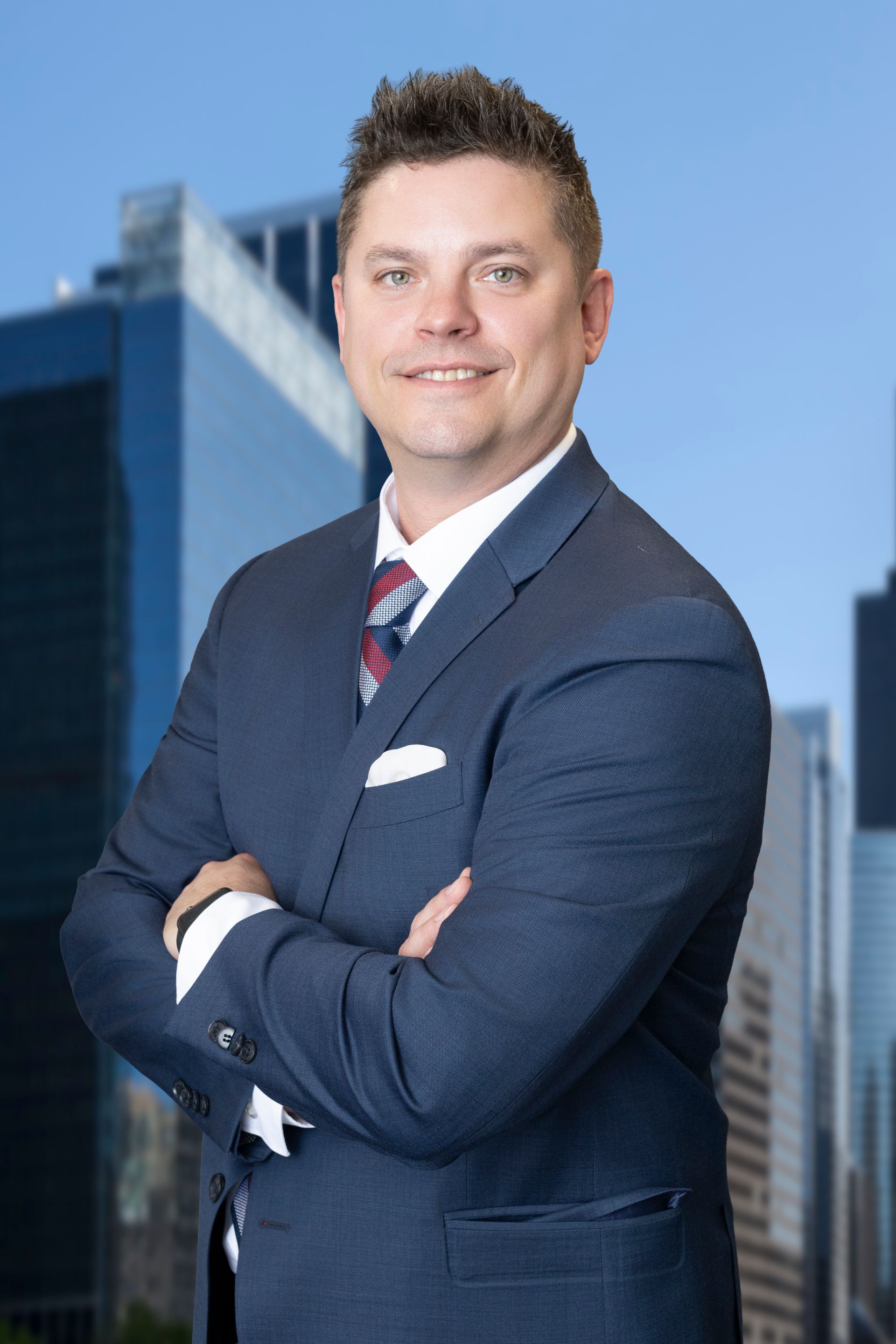 A man in a suit and tie is smiling for the camera